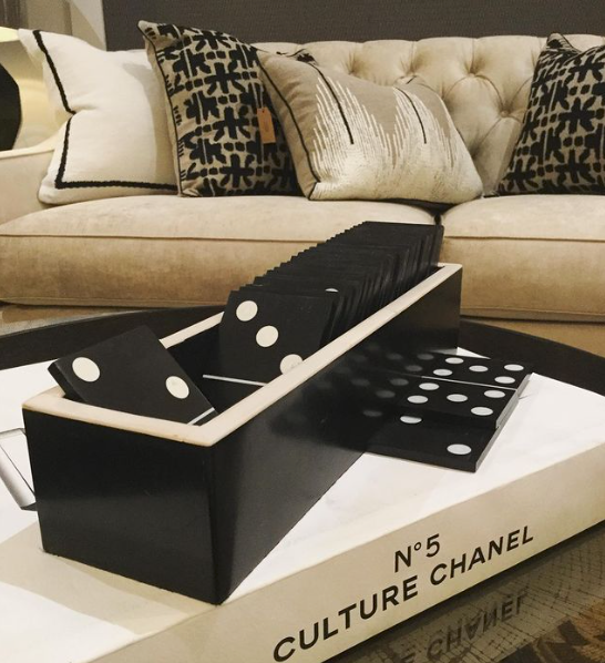 Domino Games set on Chanel book with cushions and sofa in back