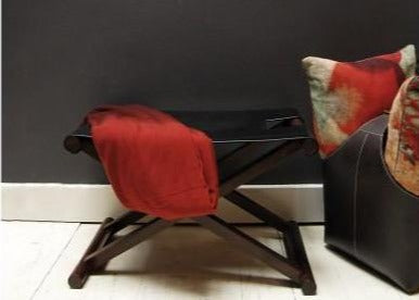 Black Leather Shikari Stool in home with red throw and cushions