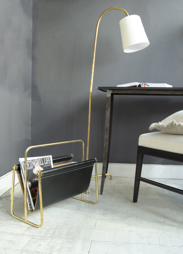 Magazine rack in corner with desk and lamp